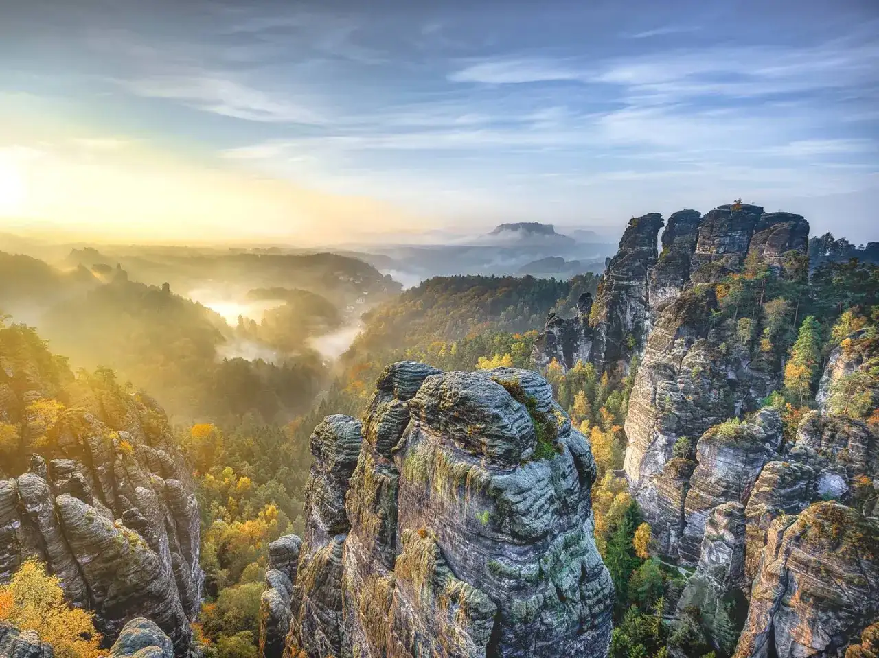 Morgendlicher Nebel über Felsformationen und Wäldern in der Sächsischen Schweiz. Ein perfekter Ort für einen Urlaub in Sachsen.