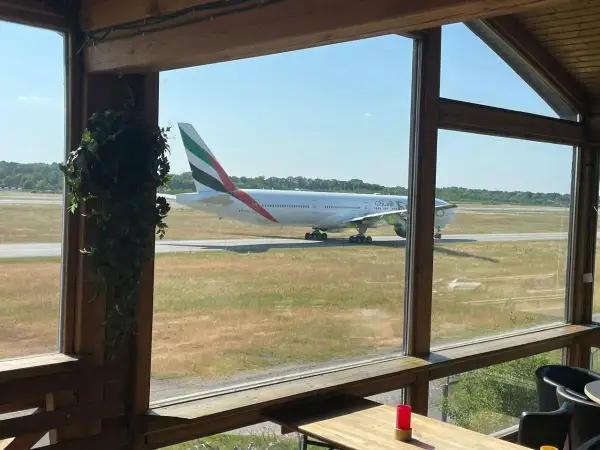 Ein Emirates-Flugzeug rollt auf dem Rollfeld. Perfekt für ein "Cafe to fly" mit Aussicht.